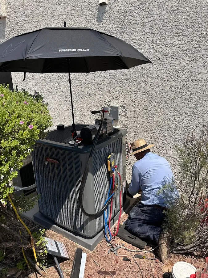 HVAC technician performing outdoor AC maintenance in Deming