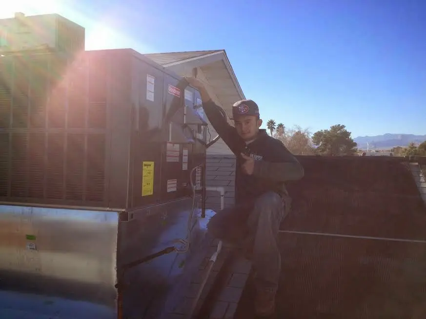 HVAC technician performing HVAC Inspection on a rooftop unit in Deming